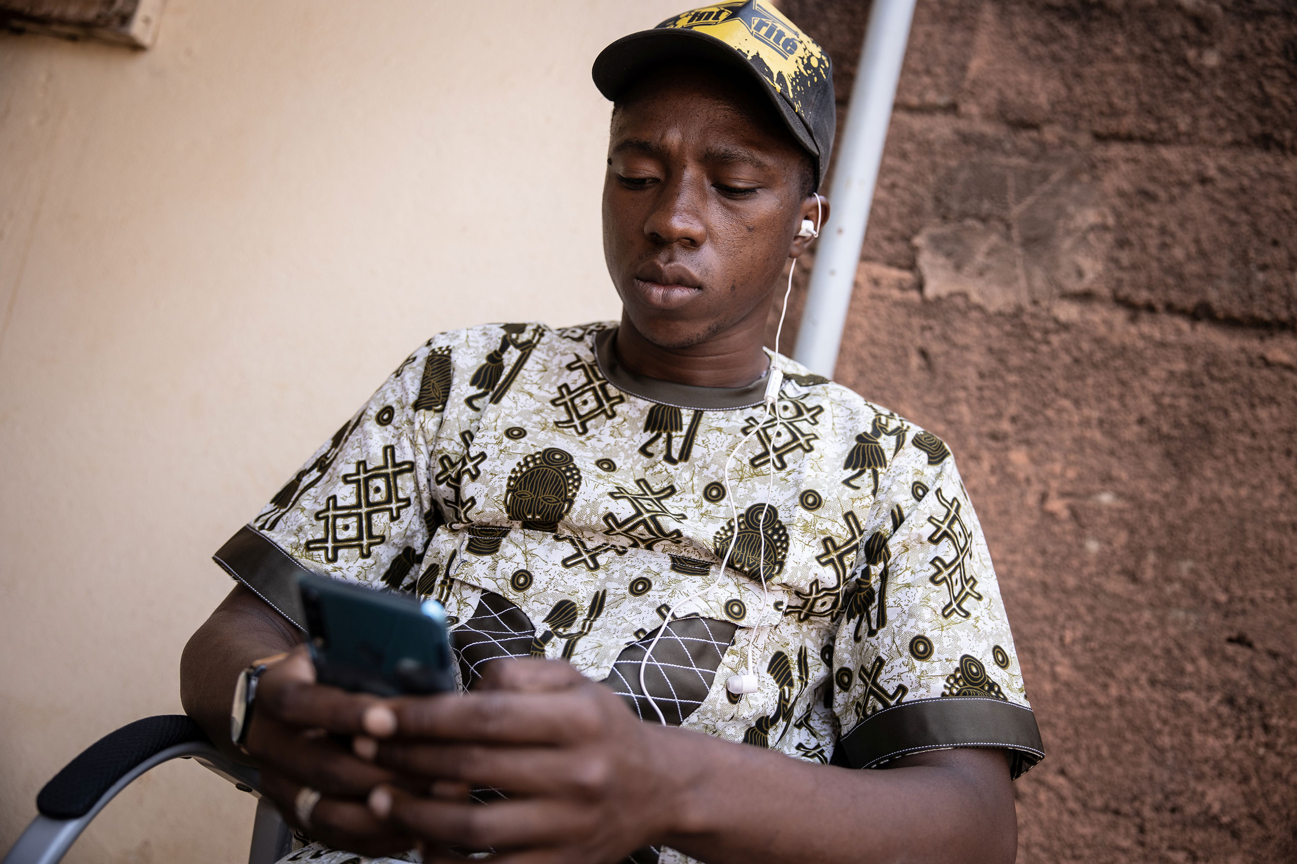 Un jeune homme écoute le Studio Yafa sur son téléphone à travers le service VIAMO. © Olympia de Maismont / Fondation Hirondelle.