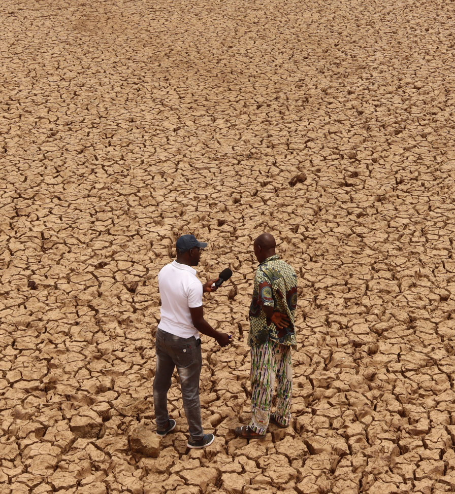 Un journaliste questionne un riverain du barrage de Mogtedo, sur le lac de retenue à sec. © Studio Yafa / Fondation Hirondelle.